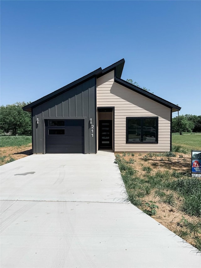 211 N 4th St, Grandview, TX 76050 - view of front of house with board and batten siding, driveway, and an attached garage