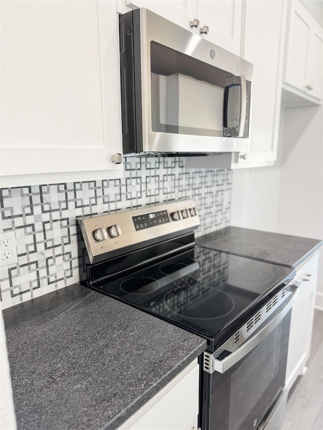 211 N 4th St, Grandview, TX 76050 - kitchen featuring appliances with stainless steel finishes, white cabinetry, and tasteful backsplash