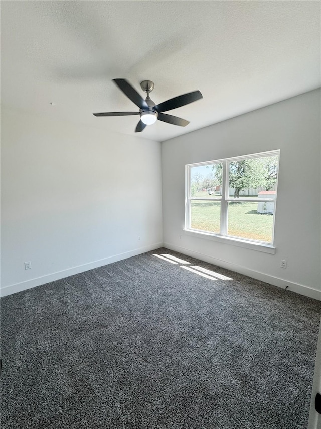 211 N 4th St, Grandview, TX 76050 - spare room with baseboards, ceiling fan, dark carpet, and a textured ceiling