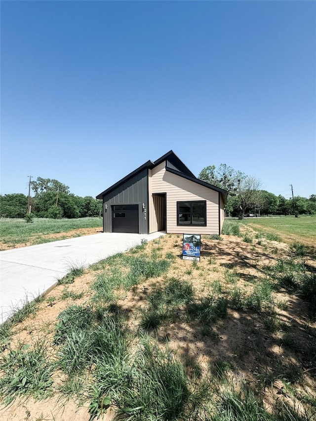 211 N 4th St, Grandview, TX 76050 - view of property exterior featuring a garage, board and batten siding, and driveway