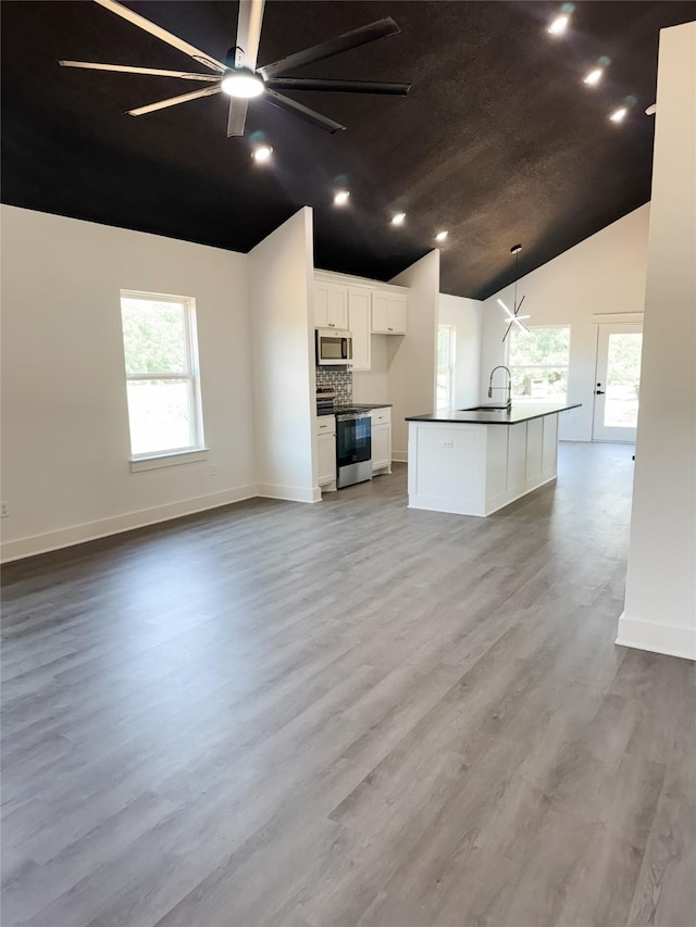 211 N 4th St, Grandview, TX 76050 - kitchen with stainless steel appliances, dark countertops, open floor plan, healthy amount of natural light, and high vaulted ceiling