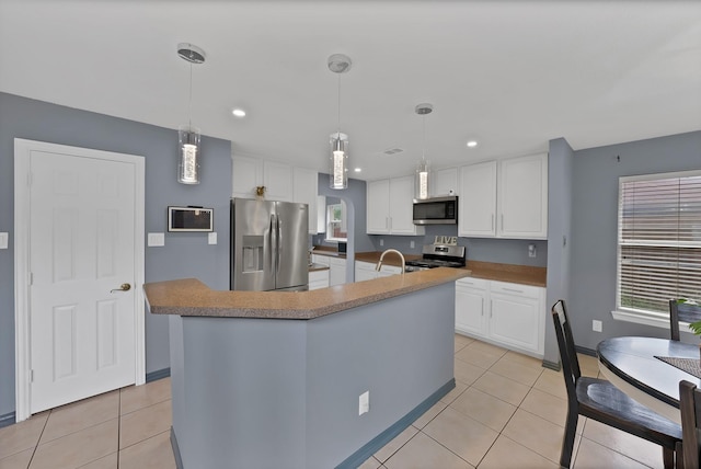 kitchen featuring stainless steel appliances, white cabinetry, light tile patterned floors, a kitchen island with sink, and recessed lighting