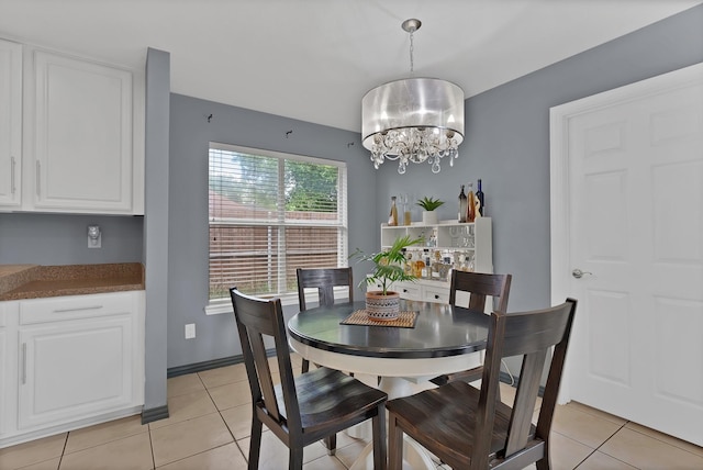 dining area with light tile patterned flooring and a chandelier
