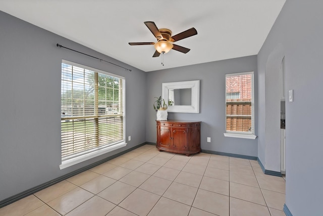 empty room with a ceiling fan and baseboards
