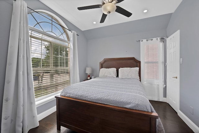 bedroom with vaulted ceiling, dark wood-style floors, baseboards, and a ceiling fan