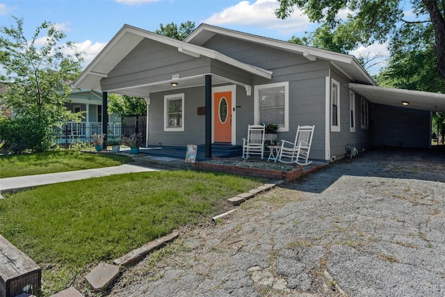 1217 Hawthorne Ave, Fort Worth, TX 76110 - view of front of property with covered porch, driveway, an attached carport, and a front lawn