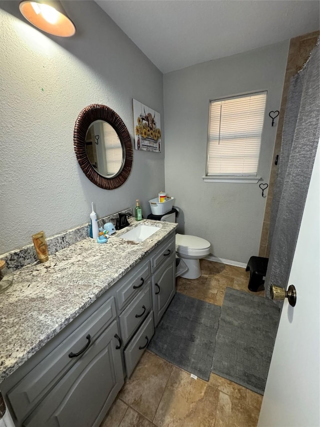 1400 Royal Ln, Cisco, TX 76437 - bathroom with vanity, toilet, stone finish floors, and curtained shower