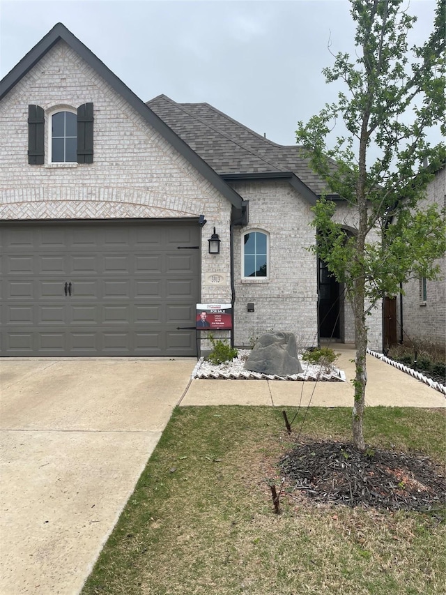 3913 Crystal Cv, Sherman, TX 75090 - french country home featuring brick siding, a shingled roof, and driveway