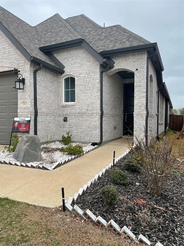 3913 Crystal Cv, Sherman, TX 75090 - view of home's exterior with brick siding, roof with shingles, and an attached garage
