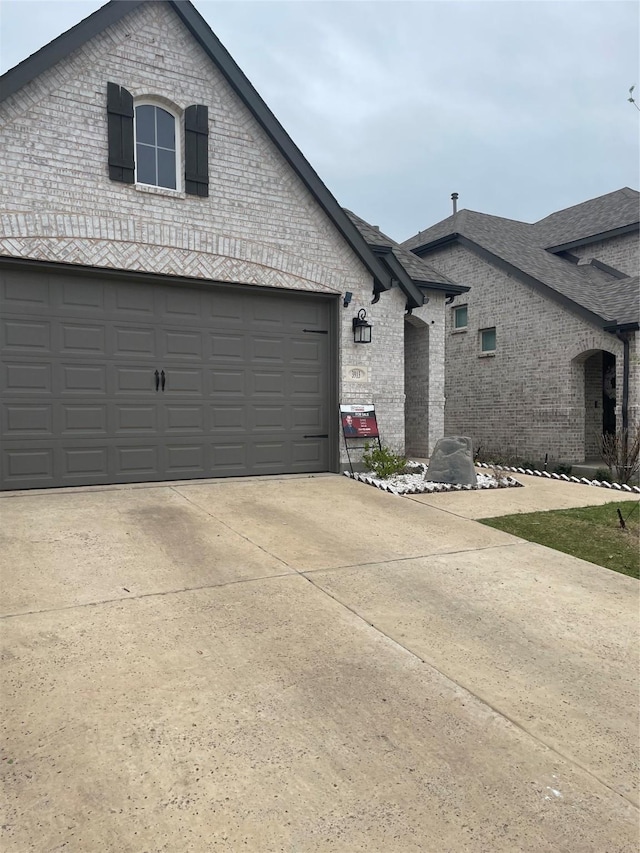 3913 Crystal Cv, Sherman, TX 75090 - view of side of home featuring brick siding, concrete driveway, a garage, and roof with shingles