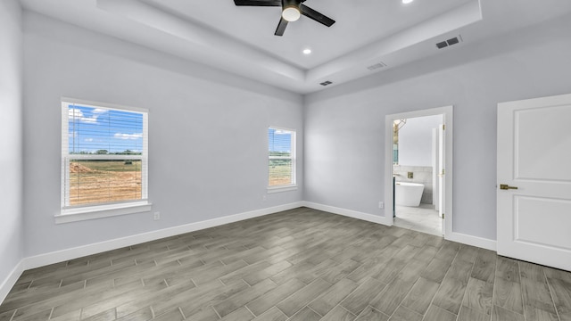 140 Rolling Hills Blvd, Alvord, TX 76225 - unfurnished bedroom featuring a tray ceiling, wood finished floors, baseboards, recessed lighting, and ensuite bathroom