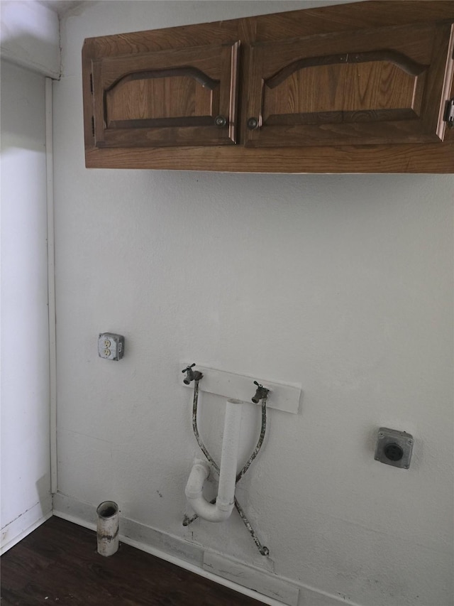 811 Vincent St, Brownwood, TX 76801 - washroom featuring cabinet space, electric dryer hookup, baseboards, dark wood finished floors, and hookup for a gas dryer