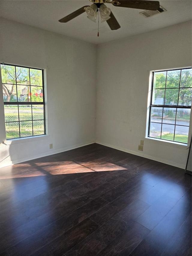 811 Vincent St, Brownwood, TX 76801 - unfurnished room with dark wood-type flooring, plenty of natural light, a ceiling fan, and baseboards