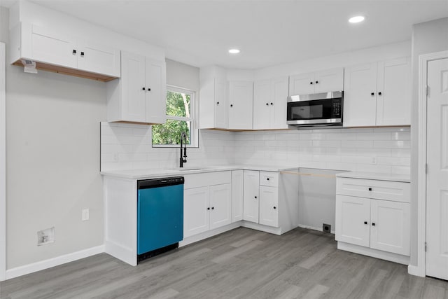 2208 Jane St, Waco, TX 76711 - kitchen featuring stainless steel microwave, dishwashing machine, light wood-style flooring, a sink, and recessed lighting