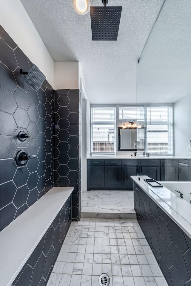 4506 Sky Harbor Dr, Rockwall, TX 75087 - bathroom featuring marble finish floors, a textured ceiling, tiled shower, and vanity