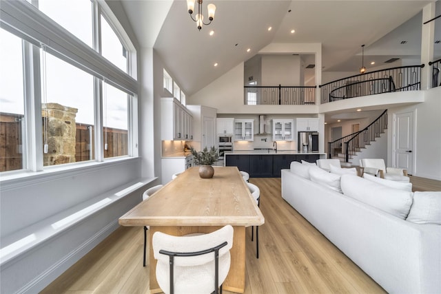 4506 Sky Harbor Dr, Rockwall, TX 75087 - living room featuring a high ceiling, light wood-style floors, stairs, and a chandelier