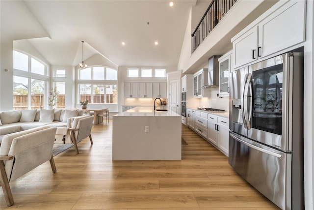 4506 Sky Harbor Dr, Rockwall, TX 75087 - kitchen featuring stainless steel appliances, wall chimney exhaust hood, healthy amount of natural light, open floor plan, and high vaulted ceiling