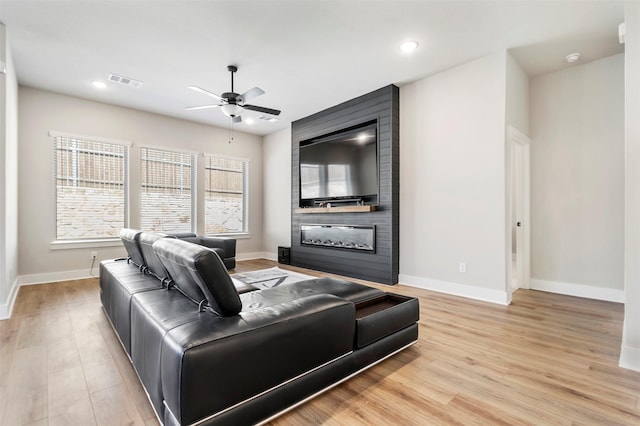 living room with ceiling fan, baseboards, a fireplace, and recessed lighting