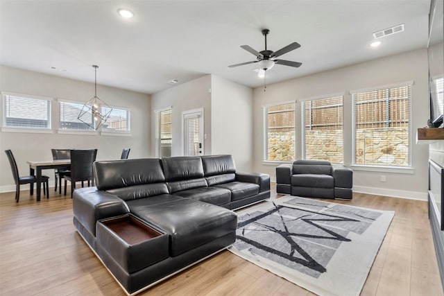 living room with baseboards, ceiling fan, light wood-type flooring, and recessed lighting