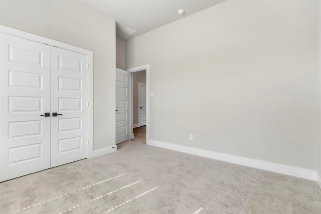 unfurnished bedroom featuring carpet, a closet, and baseboards