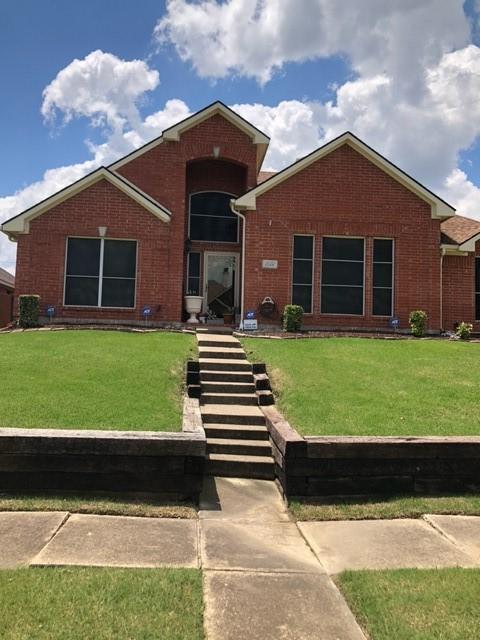 ranch-style house with brick siding and a front yard