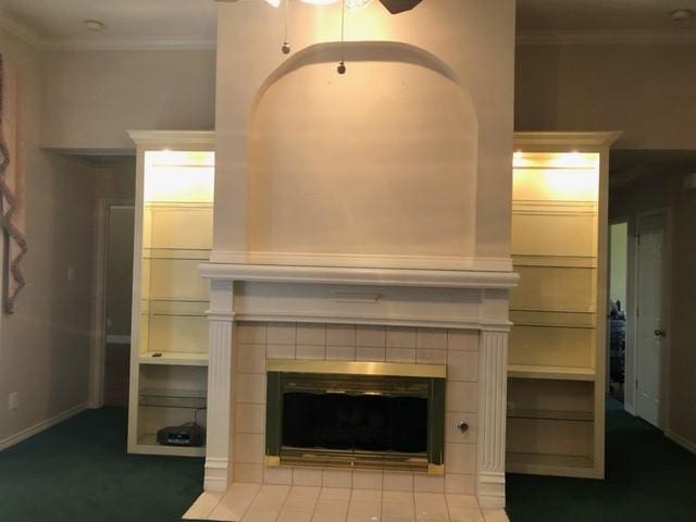 unfurnished living room with ornamental molding, a tile fireplace, and ceiling fan