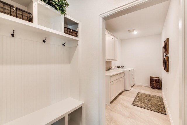 mudroom with washer and clothes dryer and baseboards