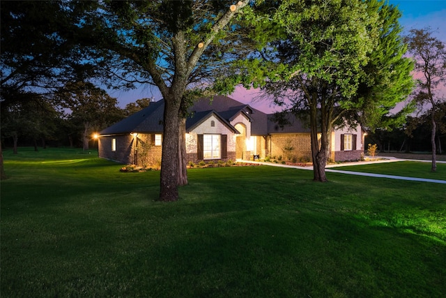 view of front of house with a lawn and brick siding
