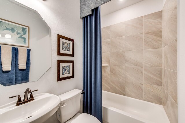 bathroom with a sink, toilet, and shower / bath combo