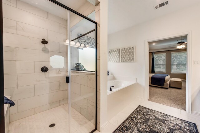 ensuite bathroom featuring a bath, a shower stall, ceiling fan, and baseboards