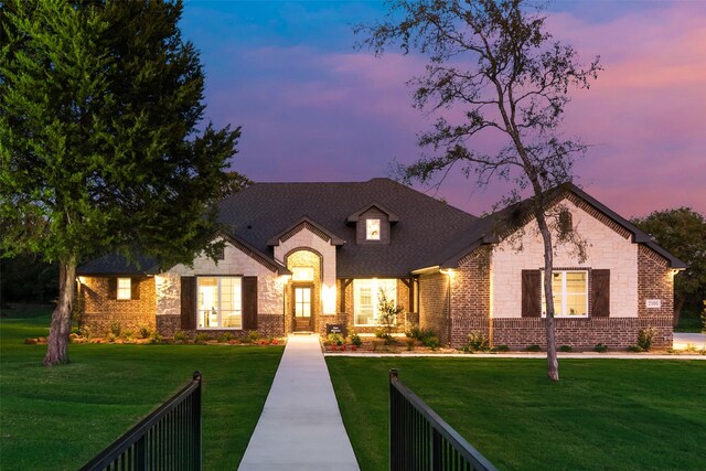 french country style house with stone siding and brick siding