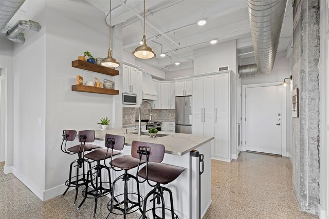221 W Lancaster Ave Unit 4012, Fort Worth, TX 76102 - kitchen featuring appliances with stainless steel finishes, a sink, a breakfast bar, baseboards, and a peninsula