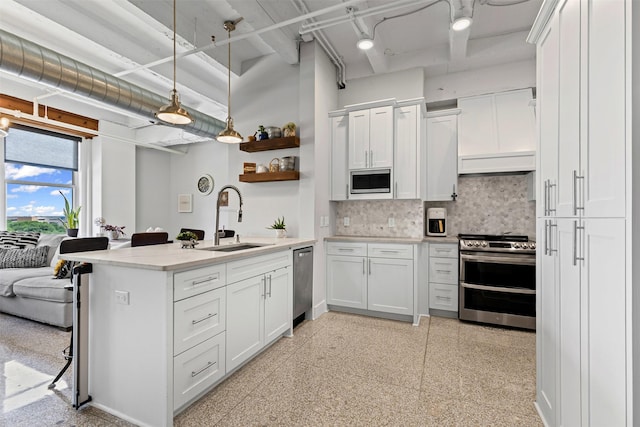 221 W Lancaster Ave Unit 4012, Fort Worth, TX 76102 - kitchen with appliances with stainless steel finishes, a sink, a peninsula, open shelves, and decorative backsplash