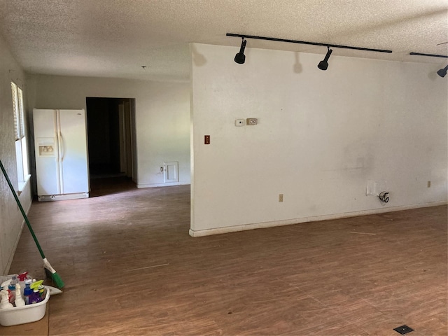 12735 County Road 2922, Eustace, TX 75124 - spare room featuring a textured ceiling, wood finished floors, track lighting, and baseboards