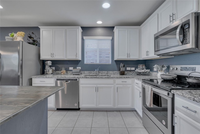2208 Heaton St, Forney, TX 75126 - kitchen with stainless steel appliances, a sink, recessed lighting, white cabinetry, and light tile patterned flooring