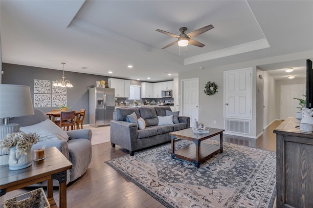 2208 Heaton St, Forney, TX 75126 - living area with a tray ceiling, ceiling fan, ornamental molding, a chandelier, and wood finished floors
