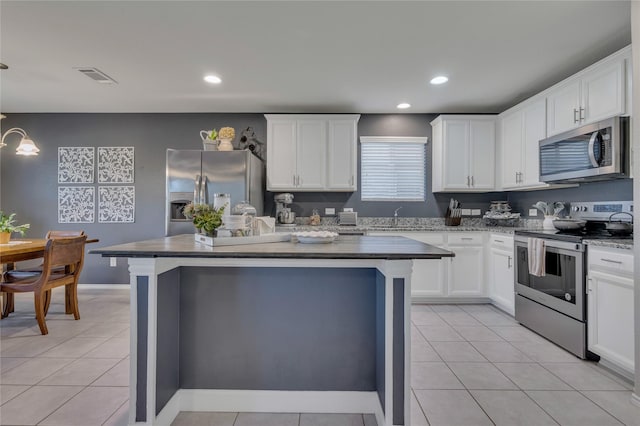 2208 Heaton St, Forney, TX 75126 - kitchen with stainless steel appliances, a center island, recessed lighting, a sink, and white cabinets