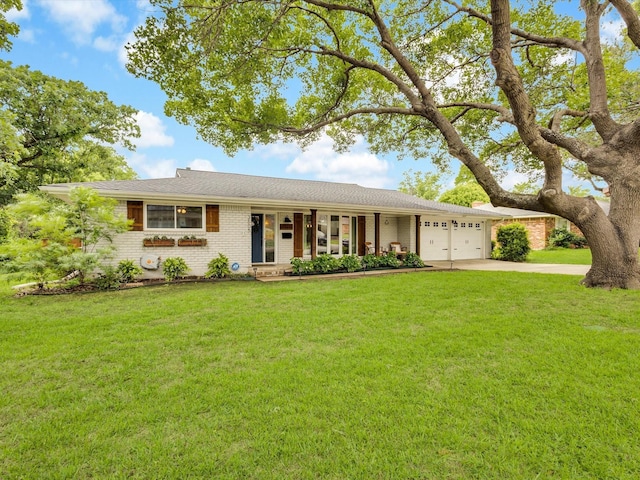 single story home with an attached garage, brick siding, driveway, and a front yard