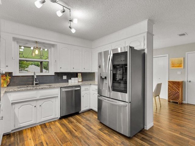 kitchen featuring stainless steel appliances, a sink, dark wood-type flooring, white cabinetry, and a textured ceiling