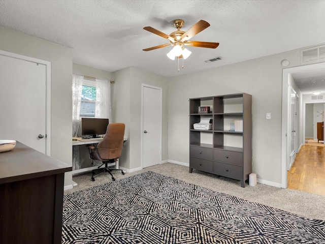 carpeted office featuring ceiling fan and baseboards