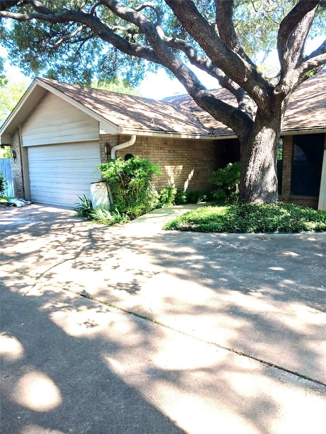 2435 St Gregory St, Arlington, TX 76013 - view of front of home featuring brick siding, an attached garage, and driveway