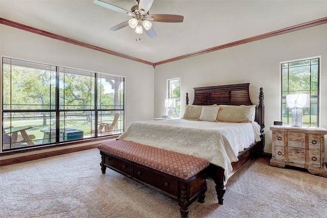 carpeted bedroom with crown molding and a ceiling fan
