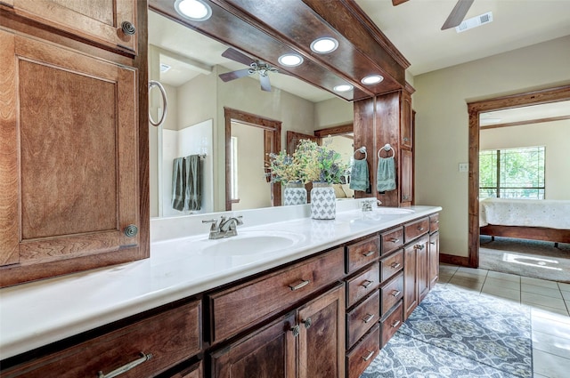 ensuite bathroom featuring ceiling fan, tile patterned floors, double vanity, recessed lighting, and baseboards
