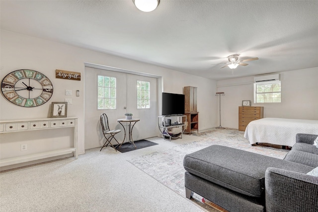bedroom with light carpet, an AC wall unit, and a ceiling fan