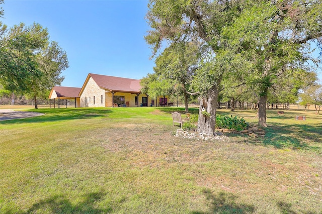 view of green lawn featuring a carport