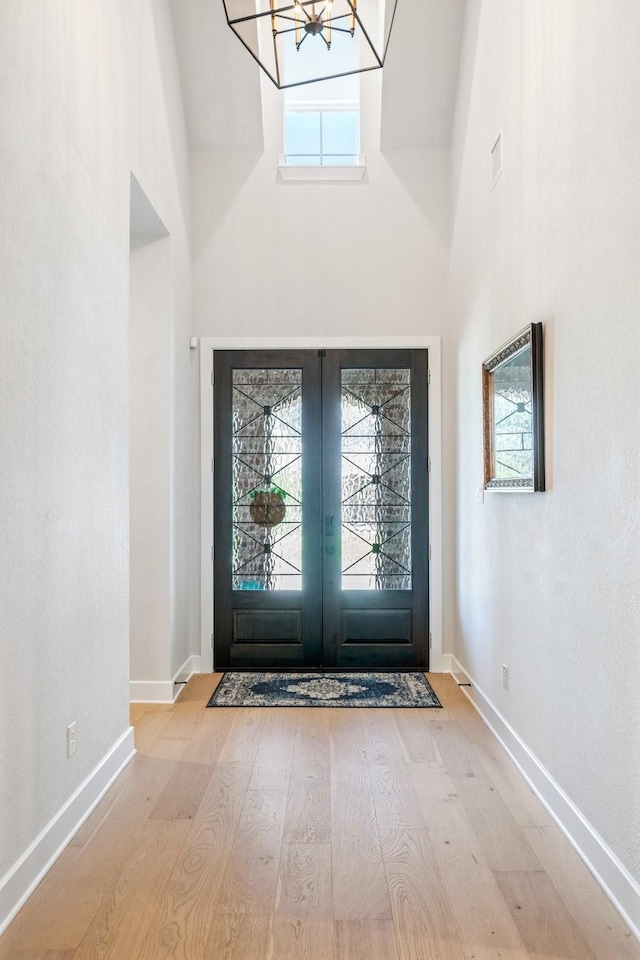 2200 Sandalwood Dr, Prosper, TX 75078 - entryway featuring a high ceiling, a chandelier, french doors, wood finished floors, and baseboards