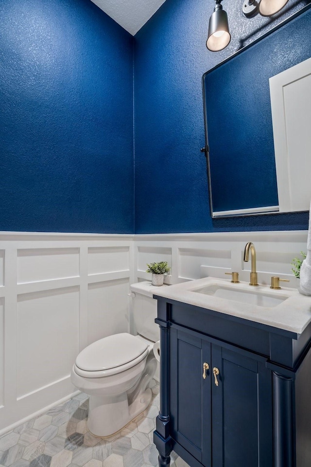 2200 Sandalwood Dr, Prosper, TX 75078 - bathroom featuring a decorative wall, toilet, a wainscoted wall, vanity, and a textured wall
