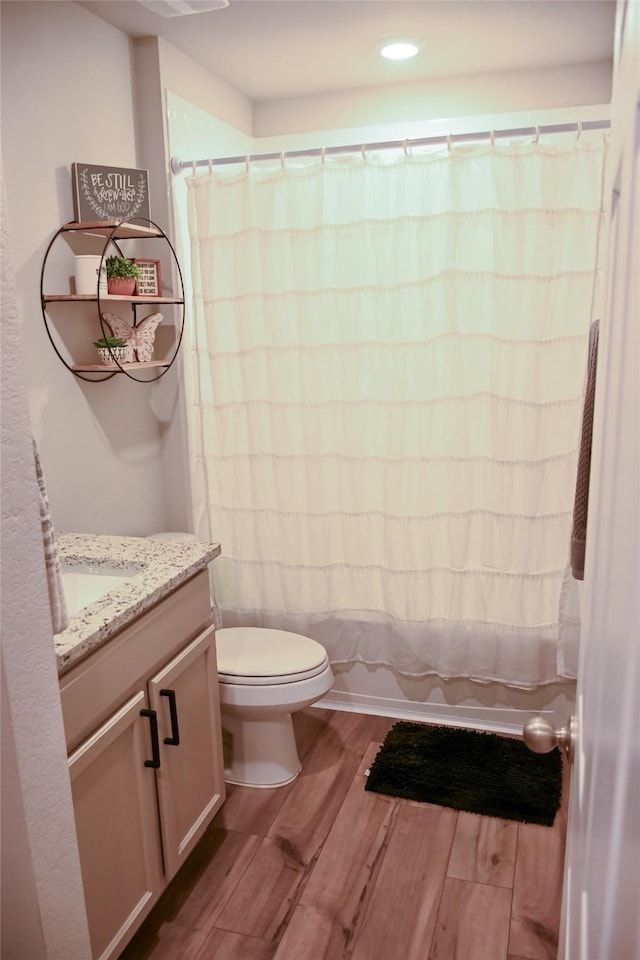 7121 Guadalupe Rd, Waco, TX 76633 - bathroom with wood finished floors, toilet, vanity, and shower / bath combination with curtain