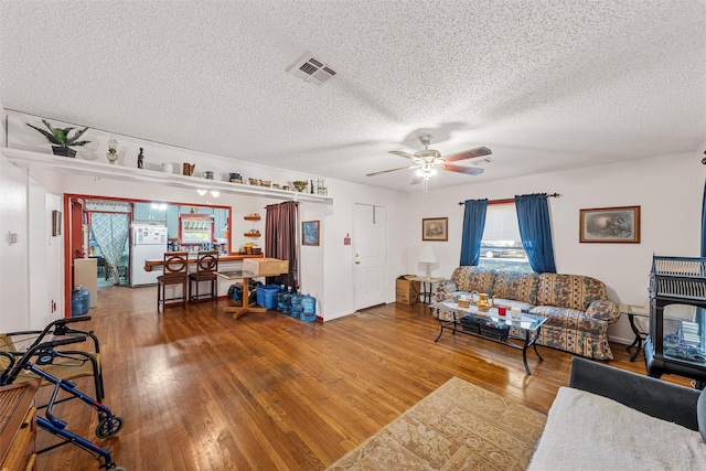 2924 Cole Ave, Waco, TX 76707 - living room with hardwood / wood-style floors, a textured ceiling, a ceiling fan, and baseboards