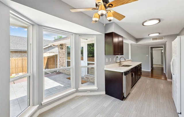 2848 Oxford Ln, Flower Mound, TX 75028 - kitchen featuring stainless steel dishwasher, dark brown cabinets, light countertops, a sink, and baseboards